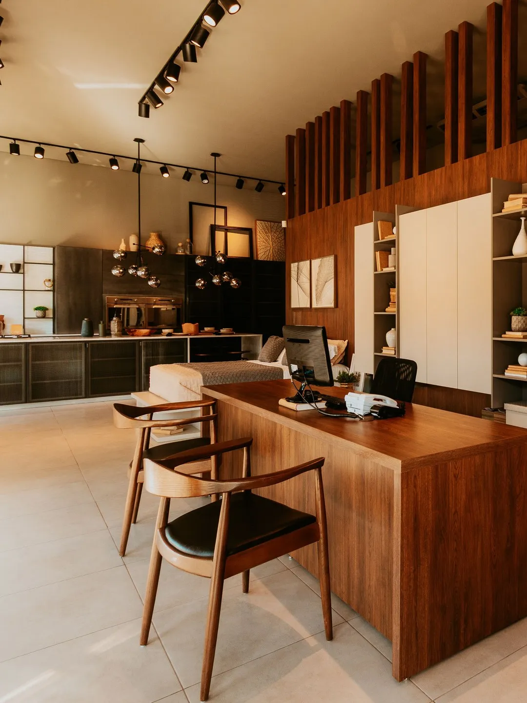 A wooden desk with a monitor and two chairs in a modern studio office